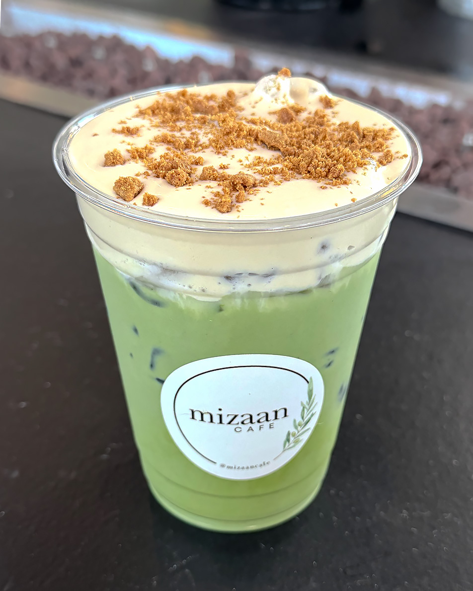 Iced matcha latte topped with cookie butter cream