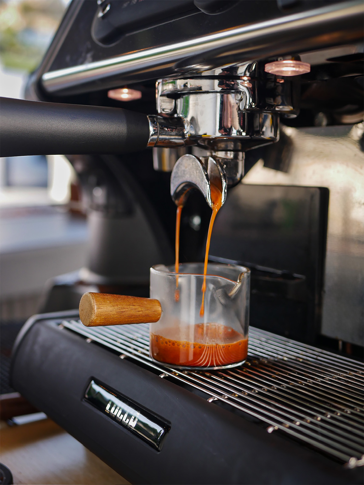 Espresso pouring into a glass shot pitcher
