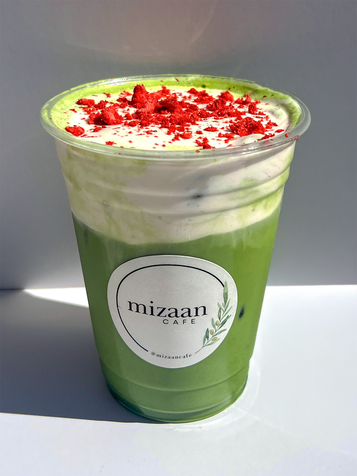 Iced matcha latte topped with strawberry cream